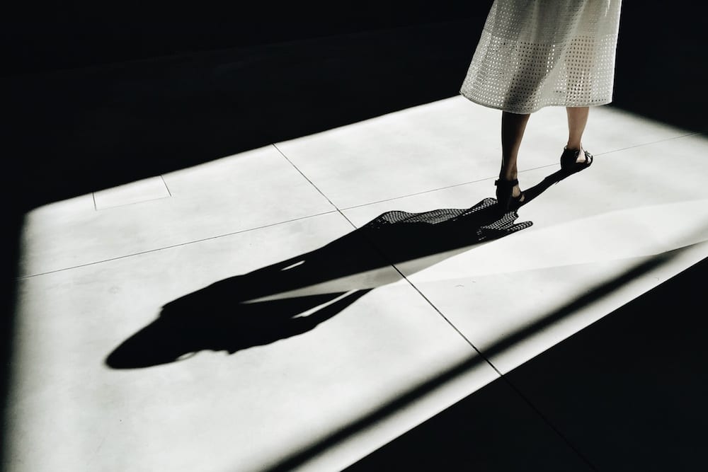woman standing in shadows