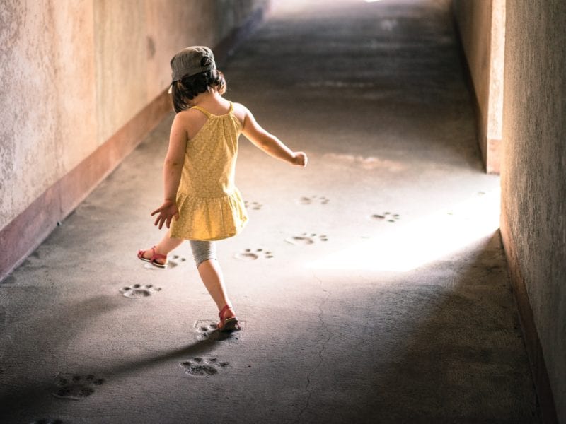a young girl stepping into the footprints of a bear