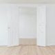 a set of double doors opening to an empty white room